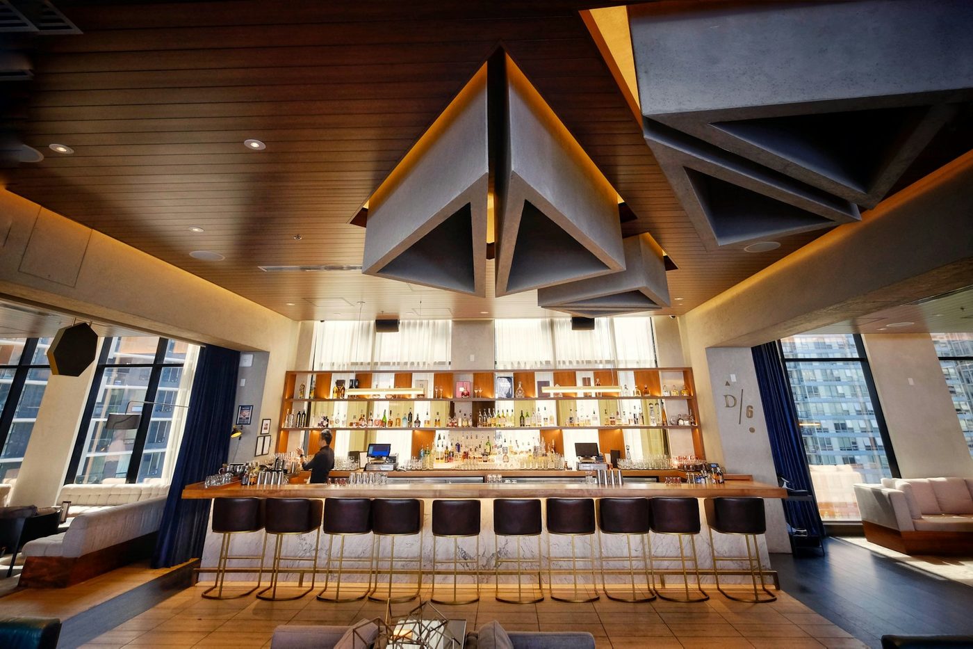 Salón con techo de madera y barra iluminada